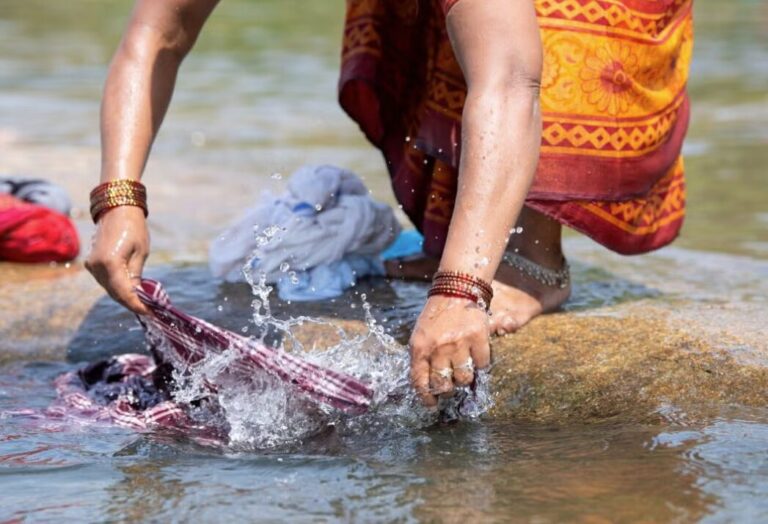 A person handwashing clothes in water